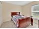 Neutral bedroom has carpet, a window with blinds and a dark-stained bed frame at 28045 Poinsettia Ave, Paisley, FL 32767
