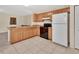 Well-lit kitchen featuring wood cabinets, tan countertops, and tiled floors at 28045 Poinsettia Ave, Paisley, FL 32767
