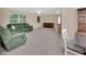Living room has carpet, neutral colors, and green upholstered furniture with natural lighting at 28045 Poinsettia Ave, Paisley, FL 32767