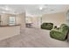 Open-concept living room features neutral colors, carpeting, and comfortable green upholstered furniture at 28045 Poinsettia Ave, Paisley, FL 32767