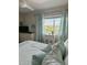 Bright bedroom featuring a coastal decor, white furniture, and a view of the landscape at 2860 Ocean Shore Blvd # 5020, Ormond Beach, FL 32176