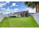 Fenced backyard with lush green lawn, a boat, and access to a screened patio at 3 Sea Dance Ter, Ormond Beach, FL 32176
