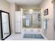 Bright bathroom featuring a glass shower enclosure, storage cabinet, and large mirror at 3 Sea Dance Ter, Ormond Beach, FL 32176