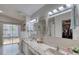 Bright bathroom with a double sink vanity, neutral color scheme, and sliding glass doors to the outside at 3 Sea Dance Ter, Ormond Beach, FL 32176
