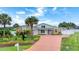Inviting single-story home featuring a lush lawn, palm trees, and a long driveway at 3 Sea Dance Ter, Ormond Beach, FL 32176