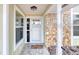 View of the front porch with stone accents, a white door and windows at 3 Sea Dance Ter, Ormond Beach, FL 32176