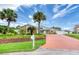 Well maintained front yard with tropical trees and an inviting driveway at 3 Sea Dance Ter, Ormond Beach, FL 32176