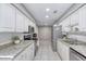 Galley style kitchen featuring white cabinetry, stainless steel appliances, and tile flooring at 3 Sea Dance Ter, Ormond Beach, FL 32176