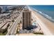 Aerial view of a high-rise condo complex with pool, parking, and beach access near a coastal highway overlooking the Atlantic Ocean at 3051 S Atlantic Ave # 1003, Daytona Beach, FL 32118