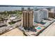 Aerial view showcasing the condo complex with a pool, ample parking, and picturesque views of the ocean and intercoastal waterway at 3051 S Atlantic Ave # 1003, Daytona Beach, FL 32118
