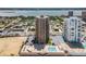 Stunning aerial view of the beachfront condo complex featuring a pool and parking area with ocean and cityscape views at 3051 S Atlantic Ave # 1003, Daytona Beach, FL 32118