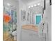 This bathroom features a single sink vanity with a mirror, toilet, and shower with blue and green accents at 3051 S Atlantic Ave # 1003, Daytona Beach, FL 32118