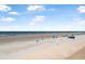 Expansive beach view with people enjoying the sun, sand, and surf under a beautiful sky with fluffy clouds at 3051 S Atlantic Ave # 1003, Daytona Beach, FL 32118