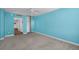 This empty bedroom offers blue walls, sliding closet, carpet flooring, and views into the hallway at 3051 S Atlantic Ave # 1003, Daytona Beach, FL 32118