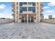 Inviting condo entrance boasting a spacious patio with brick pavers and glimpses of balconies on the upper floors at 3051 S Atlantic Ave # 1003, Daytona Beach, FL 32118