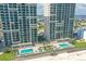 Stunning aerial view of beachfront condominiums with multiple pools, loungers, and beautiful landscaping at 3315 S Atlantic Ave # 1605, Daytona Beach Shores, FL 32118
