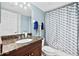 Bathroom features granite vanity, white sink, toilet, and shower with a decorative blue and white shower curtain at 3315 S Atlantic Ave # 1605, Daytona Beach Shores, FL 32118