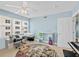 Bedroom featuring great light, a view, colorful round rug, ceiling fan, and blue accent wall at 3315 S Atlantic Ave # 1605, Daytona Beach Shores, FL 32118