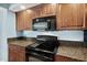 Modern kitchen featuring granite countertops and black appliances at 3315 S Atlantic Ave # 1605, Daytona Beach Shores, FL 32118