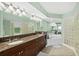 Elegant main bathroom featuring double sinks, granite countertops, and glass block shower at 3315 S Atlantic Ave # 1605, Daytona Beach Shores, FL 32118