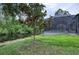 Backyard showcasing lush landscaping and screened-in patio by the water offering private outdoor living at 3428 Saltee Cir, Ormond Beach, FL 32174