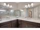 Bright bathroom featuring double sinks, quartz countertops, and a seamless glass shower enclosure at 3428 Saltee Cir, Ormond Beach, FL 32174