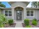 Close-up of home's entrance showing the arched door and surrounding green landscaping at 3428 Saltee Cir, Ormond Beach, FL 32174