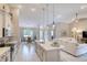 Open kitchen to living room with island, white cabinets, and tiled floors at 3428 Saltee Cir, Ormond Beach, FL 32174