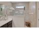 Modern shower featuring glass enclosure, neutral tiling, a small window, and a wooden stool at 3428 Saltee Cir, Ormond Beach, FL 32174