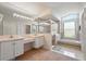 Bright bathroom features double sinks, a glass-enclosed shower, and a soaking tub, offering a spa-like experience at 3776 Sweet Grove Ct, Port Orange, FL 32129