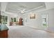 Large bedroom featuring a tray ceiling, fan, and ample natural light, providing a comfortable and inviting space at 3776 Sweet Grove Ct, Port Orange, FL 32129