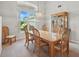 Bright dining room features a large window, elegant chandelier, and classic wood furniture for sophisticated dining at 3776 Sweet Grove Ct, Port Orange, FL 32129