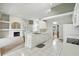 Open concept kitchen with white cabinets and island, adjacent to a living area with fireplace at 3776 Sweet Grove Ct, Port Orange, FL 32129