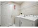 Functional laundry room with a washer, dryer, overhead shelf, and a door at 3776 Sweet Grove Ct, Port Orange, FL 32129
