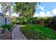 Lush backyard with a brick pathway, mature trees, a shed, and inviting spaces for outdoor enjoyment and relaxation at 4204 Rocky Ridge Pl, Sanford, FL 32773