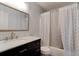 The bathroom boasts a marble countertop, dark vanity, and tiled shower with decorative shower curtain at 4204 Rocky Ridge Pl, Sanford, FL 32773