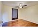 A cozy bedroom featuring wood-look floors, a ceiling fan, and a large window at 4204 Rocky Ridge Pl, Sanford, FL 32773