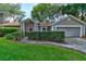 Charming single-story home with mature landscaping, a red front door, and an attached two-car garage at 4204 Rocky Ridge Pl, Sanford, FL 32773