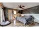 This main bedroom boasts a decorative brick wall, wood floors, ceiling fan, and en suite bathroom at 4204 Rocky Ridge Pl, Sanford, FL 32773