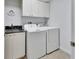 Laundry room featuring washer, dryer, sink and overhead cabinets at 424 Luna Bella Ln # 330, New Smyrna Beach, FL 32168