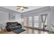 Sunlit living room features wood flooring, a ceiling fan, a comfortable sofa, and access to a balcony at 424 Luna Bella Ln # 330, New Smyrna Beach, FL 32168