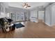 Spacious living room with wood floors, a ceiling fan, access to the balcony, and an open doorway at 424 Luna Bella Ln # 330, New Smyrna Beach, FL 32168