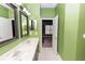 Bathroom with dual sinks, green walls, and access to a bedroom and walk in closet at 452 Casa Marina Pl, Sanford, FL 32771