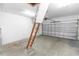 Spacious garage with concrete floor, white walls, an attic ladder, and a large sectional metal garage door at 452 Casa Marina Pl, Sanford, FL 32771