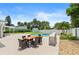 Inviting backyard with pool, dining table, lush landscaping, and privacy fence at 4638 Saxon Dr, New Smyrna Beach, FL 32169