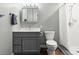Modern bathroom with gray vanity, tiled shower with glass door and modern fixtures at 4638 Saxon Dr, New Smyrna Beach, FL 32169