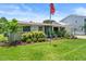 Charming single-story home with a well-manicured lawn and colorful landscaping at 4638 Saxon Dr, New Smyrna Beach, FL 32169