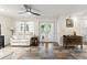 Living room with white leather furniture, stylish flooring, bright natural light, and a ceiling fan at 4638 Saxon Dr, New Smyrna Beach, FL 32169
