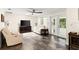 Cozy living room with white leather furniture, stylish flooring, and French doors leading to the outdoors at 4638 Saxon Dr, New Smyrna Beach, FL 32169