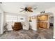 A spacious living room featuring unique tile flooring, a ceiling fan, and abundant natural light from large windows at 4638 Saxon Dr, New Smyrna Beach, FL 32169